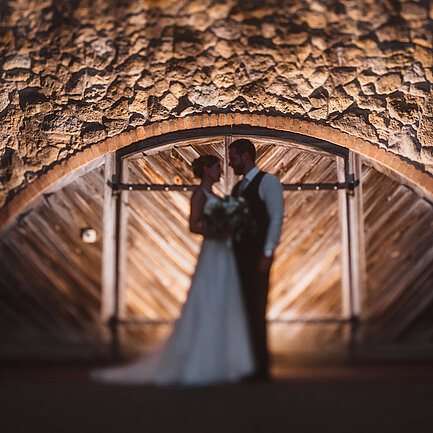 Hochzeitspaar steht vor einem Tor beim Hotel das Eisenberg.