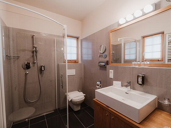 Badezimmer mit Dusche, Waschbecken und WC im Zimmer Lavendel im Romantik Stadl vom Hotel das Eisenberg.