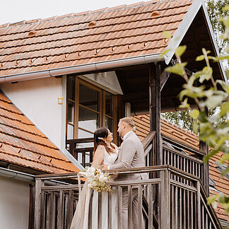 Brautpaar steht am Balkon beim Hotel das Eisenberg.