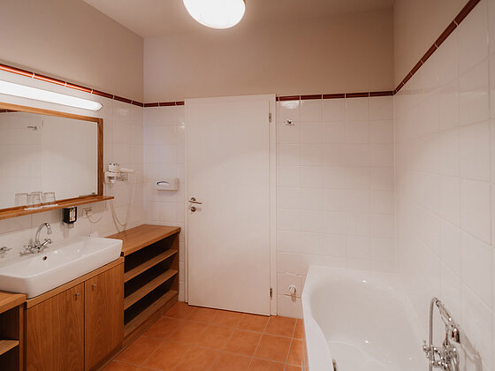 Badezimmer mit Badewanne und Waschbecken im Landhaus Doppelzimmer Lavendel im Hotel das Eisenberg.