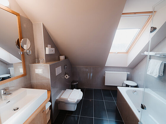Badezimmer mit Badewanne, Waschbecken und WC in der Suite Sonnenblume im Romantik Stadl vom Hotel das Eisenberg.
