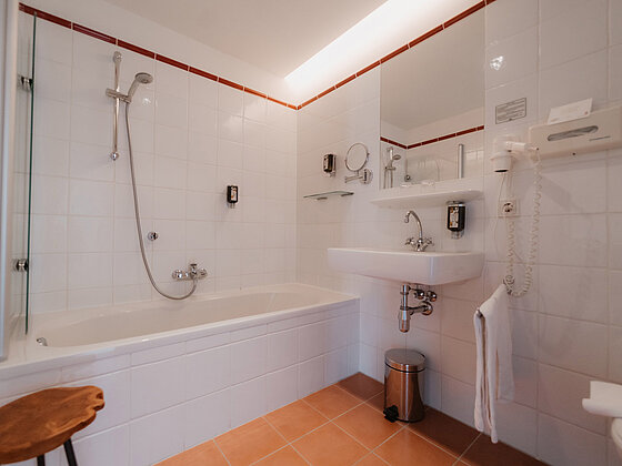 Badezimmer mit Badewanne und Waschbecken in der Junior-Suite Sonnenblume im Hotel das Eisenberg.