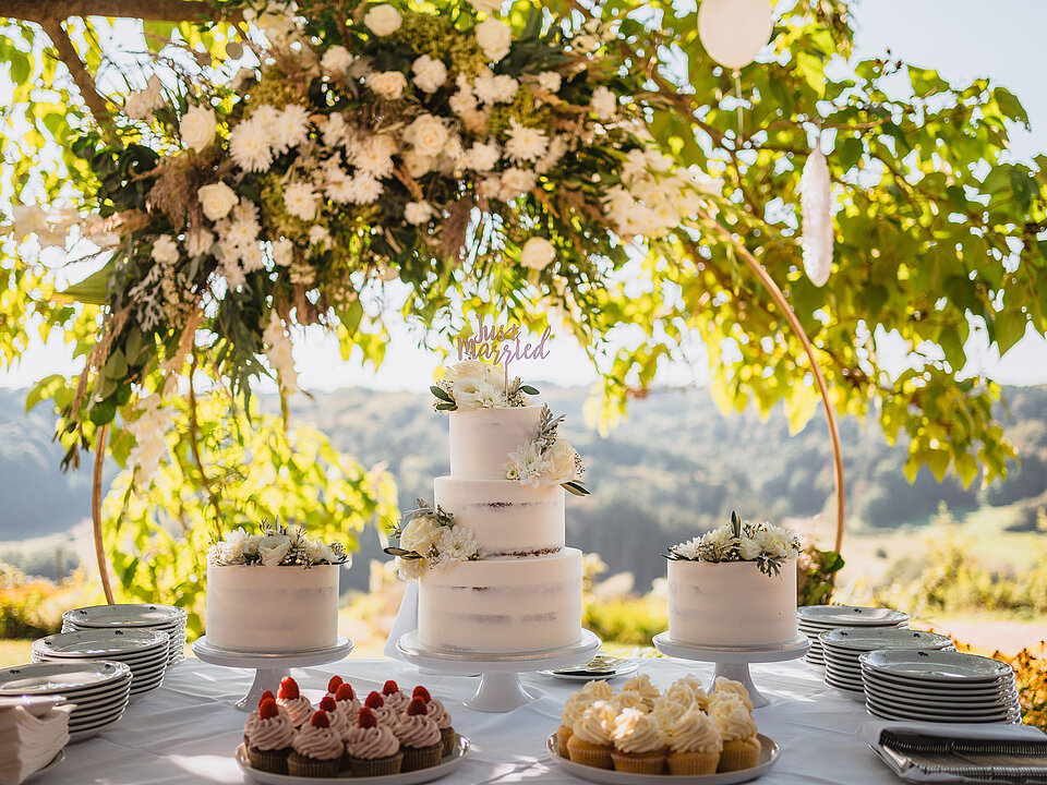 Gedeckter Hochzeitstisch mit Hochzeitstorte im Freien beim Hotel das Eisenberg.