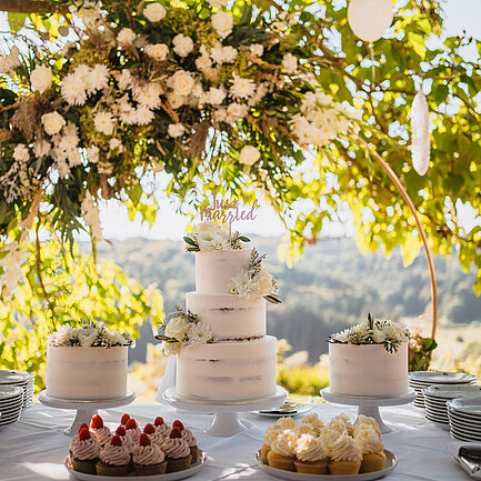 Gedeckter Hochzeitstisch mit Hochzeitstorte im Freien beim Hotel das Eisenberg.