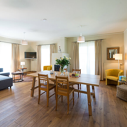 Wohnbereich mit Esstisch und Couch in der Suite Wildrose im Landhaus vom Hotel das Eisenberg (c) Jean Van Luelik Photographer.