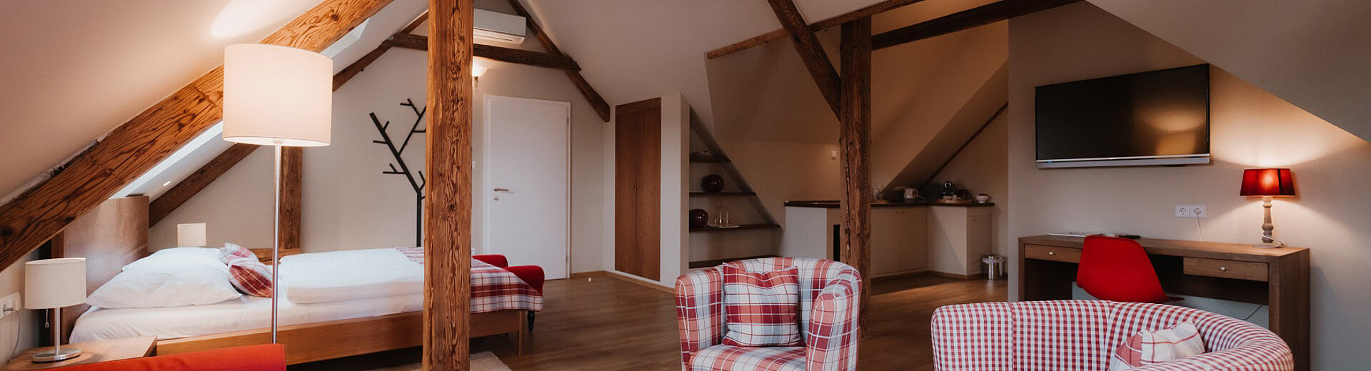 Sitzbereich mit Couch, Sesseln und Tisch im Zimmer Vergissmeinnicht im Landhaus vom Hotel das Eisenberg.