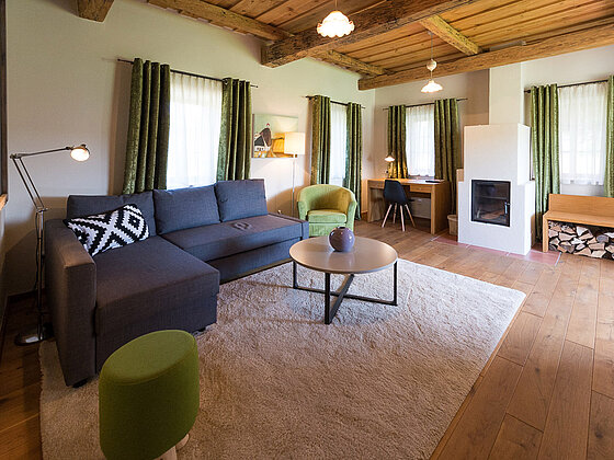 Wohnbereich mit Couch in der Suite Wildrose im Landhaus vom Hotel das Eisenberg (c) Jean Van Luelik Photographer.