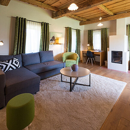 Wohnbereich mit Couch in der Suite Wildrose im Landhaus vom Hotel das Eisenberg (c) Jean Van Luelik Photographer.