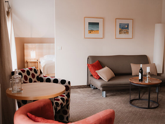 Sitzbereich mit Couch, Sessel und Tischen in der Junior-Suite Sonnenblume im Hotel das Eisenberg.