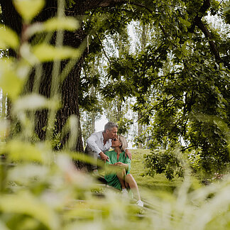 Blick durch Blätter auf den Baum im Gartenareal vom Hotel das Eisenberg.