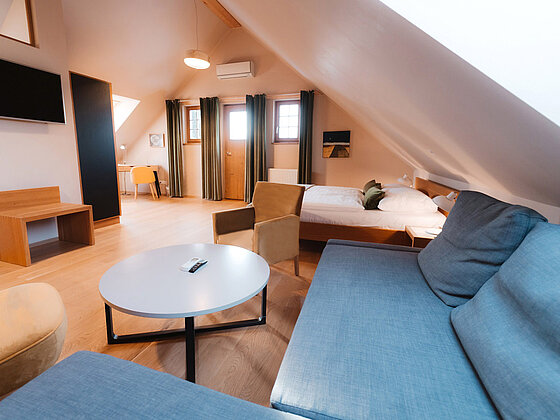 Wohnzimmer mit Couch, Tisch und Fernseher in der Suite Sonnenblume im Romantik Stadl vom Hotel das Eisenberg.